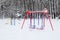 Empty Colorful Swing in Winter Time with Snow Outdoor.