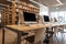 Empty computer room in the school library. Modern computers stand on a wooden table.