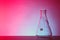 Empty conical flask on table against color background.