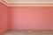 Empty coral, pink color interior with blank wall, mouldings, ceiling backlit and wooden chevron parquet floor.