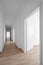 Empty corridor, white walls and wooden floor - new apartment /