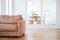 Empty couch seat in living room with wooden floor, and kitchen