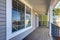 Empty covered porch with black metal railings and columns.