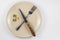 Empty cracked plate with knife and fork, it is based on three ten-coin