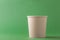 Empty craft paper disposable coffee cup or tea cup on green background