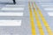 An empty crosswalk with white and yellow lines on a road, close up, outdoor