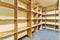 empty cubicles in a prison cell with wooden shelves