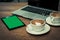 Empty cups and full coffee cup placing together with laptop