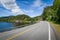 Empty curved road on the lake\'s shore in Norway