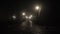 Empty dark foggy park lit by lanterns at midnight