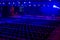 Empty dark Modern hall for events and presentation with stage and blue light. Preperation for ceremony in process. Selective focus