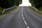 Empty dark rural asphalt highway perspective with white line