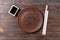 Empty dark vintage round plate with chopsticks for sushi on wooden background. Top view with copy space