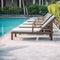 Empty deck chair around outdoor swimming pool in hotel resort for leisure vacation.