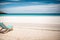 An empty deckchair overlooking a deserted sandy beach