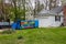 An empty decorated blue dumpster seen in the driveway of a home being renovated