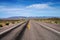 Empty desert road with scrub bushes and distant mountains in Nevada