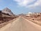 Empty desert road view with dreamy multicoloured mountains in Hormuz Island, Iran. Middle East roadtrip inspiration