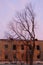 Empty destroyed building with broken windows. Pink sky Sunset. Photo in red colors. The oppressive atmosphere of destruction.