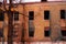 Empty destroyed building with broken windows. Pink sky Sunset. Photo in red colors. The oppressive atmosphere of destruction.