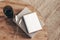 Empty diary, notepad mockup and book on round wooden table. Glass of water and dry Lagurus ovatus grass. Blurred beige