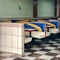 Empty diner area with white blue and yellow seats and brown and white floor tiles