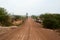 Empty dirt road going straight through barren land