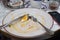 Empty dirty dish after breakfast with poached egg with tuna and cheese on toast, fork. White rustic trendy dirty plate