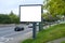 empty display on busy street, cars passing by, horizontal banner outdoor advertising in city, electronic empty blank white screen