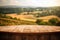 Empty Display Case For A Cosmetic Or Food Product. Wooden Podium Tabletop Blurs The Picturesque Countryside And Farmland Backdrop