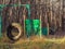 An empty dog playground with training barriers and obstacles made of wheels and wooden crossbars is located in a