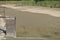 Empty and drained pond. Drought and no water in the landscape. Floodgate by the lake.