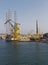 An Empty Dry Dock with its associated Port Facilities and Cranes, with an Oil Rig tied up alongside it