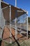 Empty dugout surrounded by chain link with dirt floor