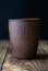 Empty earthen vessel on a wooden table. Rustic dishes. Low key.