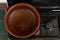 Empty earthenware casserole on an unlit gas stove