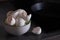 Empty eggshell in a ceramic cup on the background of a black frying pan in the kitchen.