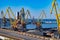 Empty elevated road and industrial port landscape with yellow metal crane jibs