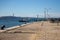 Empty embankment in Lisbon on sunny summer day. Port and riverside with lanterns and bridge on background.