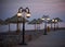 Empty embankment with straw umbrellas and streetlights in Dahab at night