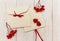 Empty envelopes with red rowan and stripe. Two red hearts jujube. White wooden table