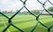 Empty fenced football field in cloudy summer