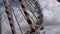 An empty Ferris wheel spins against a cloudy sky