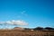 an empty field with dirt and mountains in the distance, in the far distance,