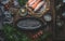 Empty fish backing pan on dark rustic kitchen table background with various fish fillets. Top view