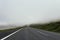 Empty foggy and misty asphalt road through the the mountain, no