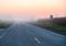 Empty foggy road at sunrise