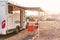 Empty folding chairs and table under canopy near recreational vehicle camper trailer