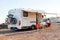 Empty folding chairs and table under canopy near recreational vehicle camper trailer