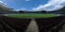 Empty football stadium with green grass and blue sky, nobody soccer field